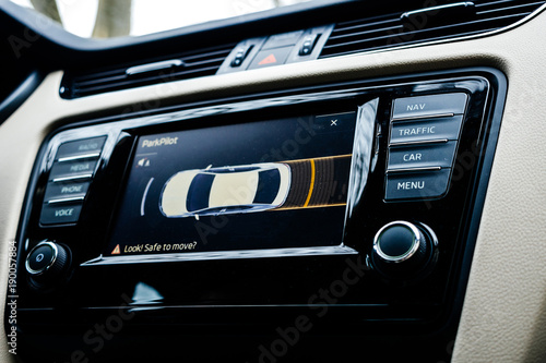 Car dashboard display showing next maneuver on the screen using the car parking sensors