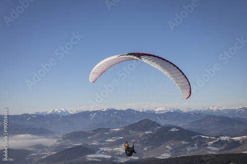 paragliding from mountain schoeckl in styria, austria. in the background mountain range hochschwab