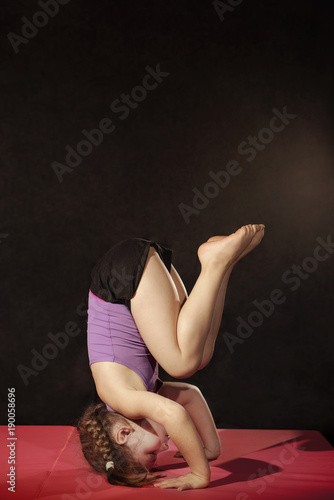 Little caucasian girl practing headstand pose