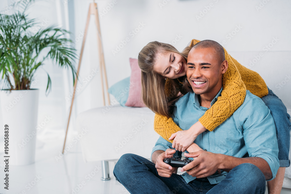 Happy Afro American girlfriend and boyfriend play games on