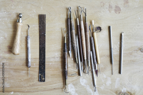 Ceramic working process, tools for hand-crafted work. View from above, wooden table