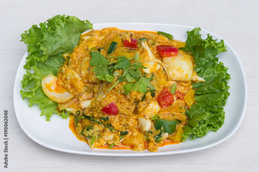 Fried crab with curry powder in white dish on the table. Fried crab with curry powder in white dish on the table.