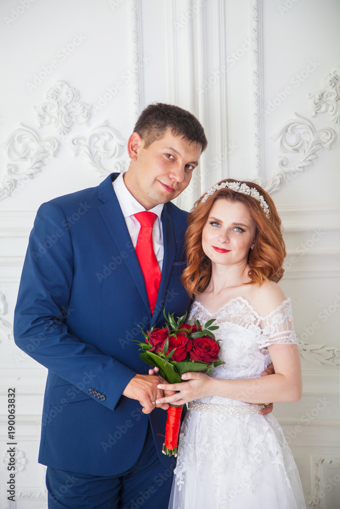 groom and bride in a bright interior. Wedding in red shades groom and bride in a bright interior. Wedding in red shades