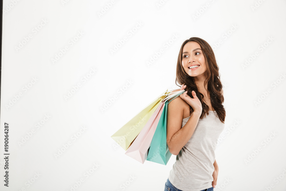 Horizontal picture of trendy woman posing on camera with shopping packs in hand, isolated over white wall copy space Horizontal picture of trendy woman posing on camera with shopping packs in hand, isolated over white wall copy space