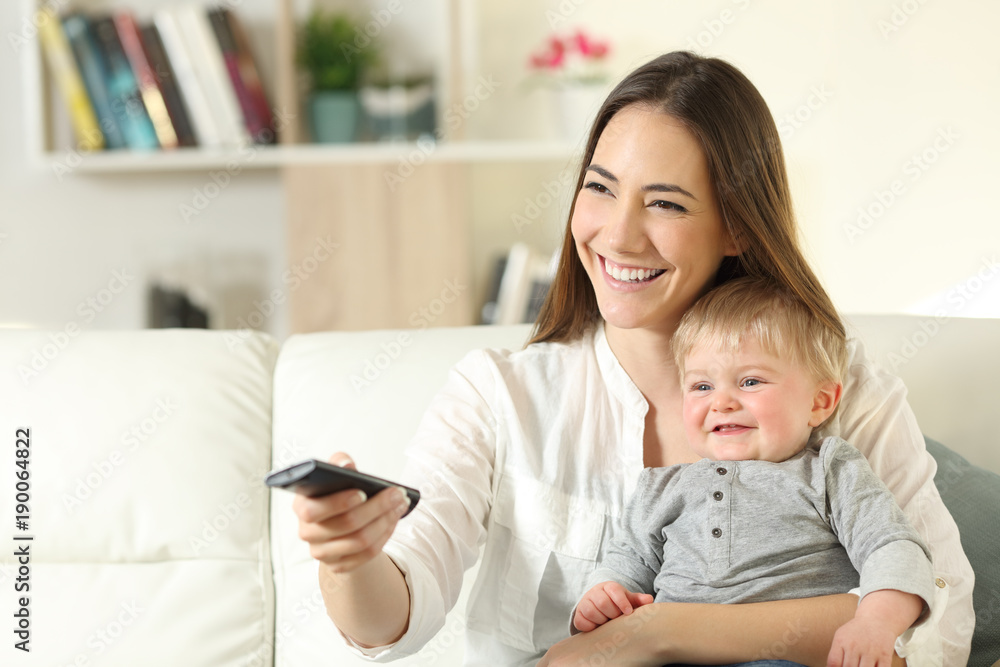 Happy mother and baby watching tv at home Happy mother and baby watching tv at home