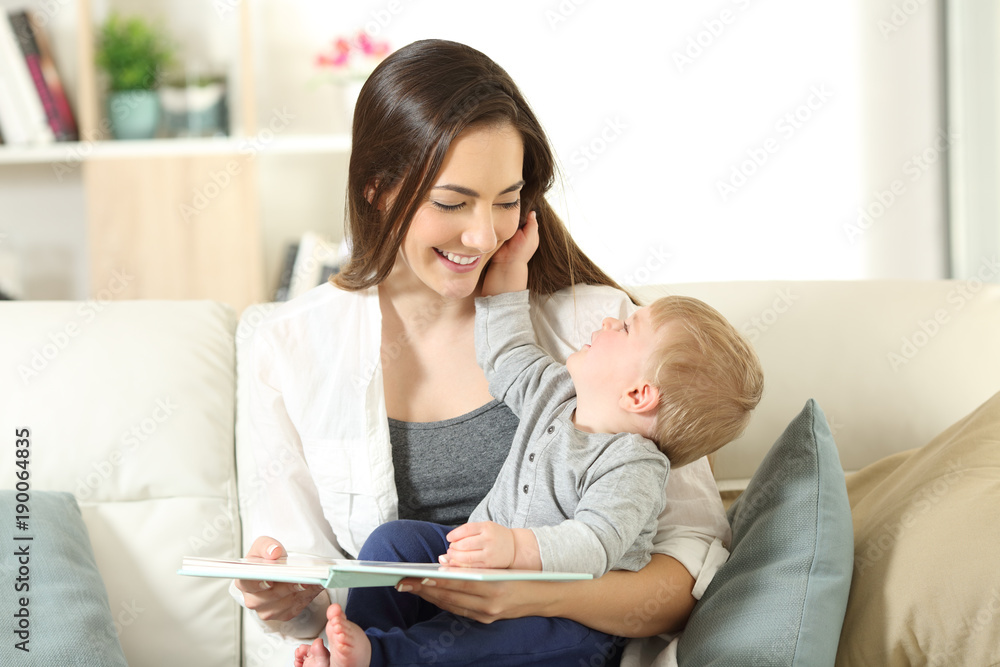 Mother and son looking each other holding a book Mother and son looking each other holding a book