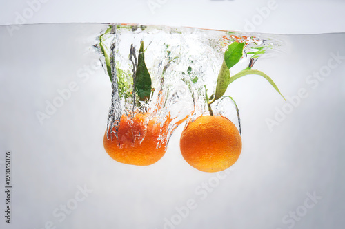 mandarins in water with a splash and air bubbles photo