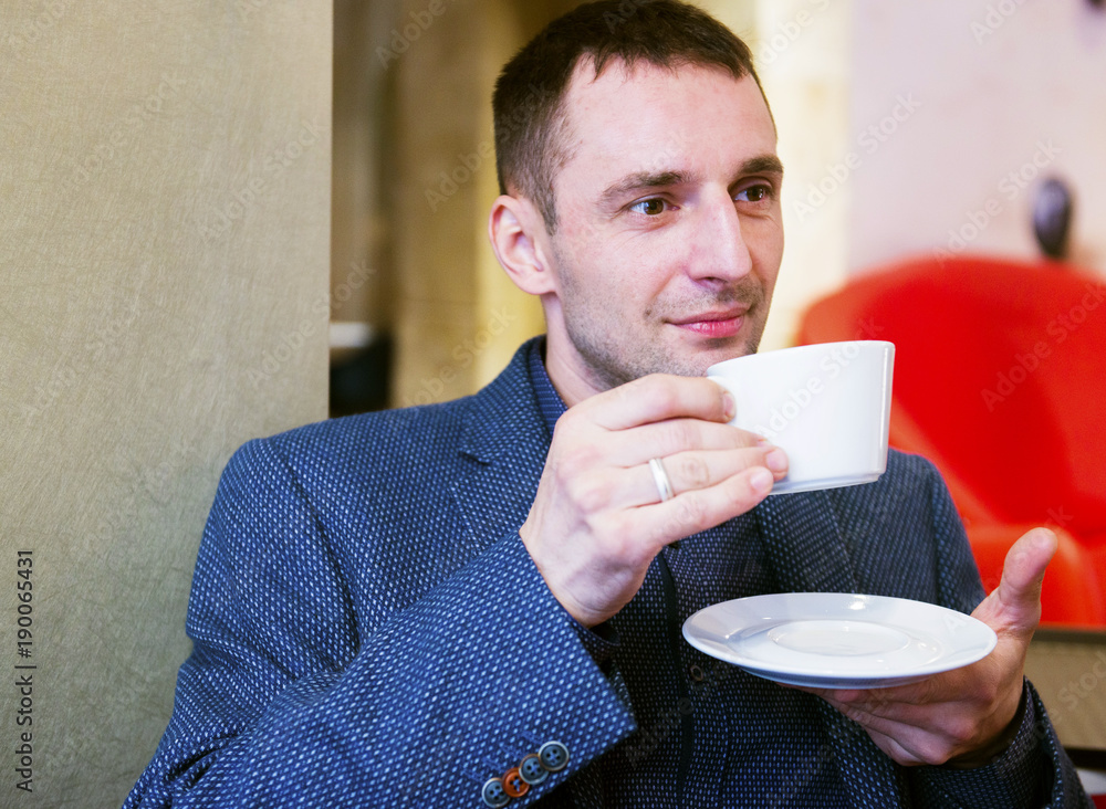 The man sits in cafe with a cup of coffee The man sits in cafe with a cup of coffee