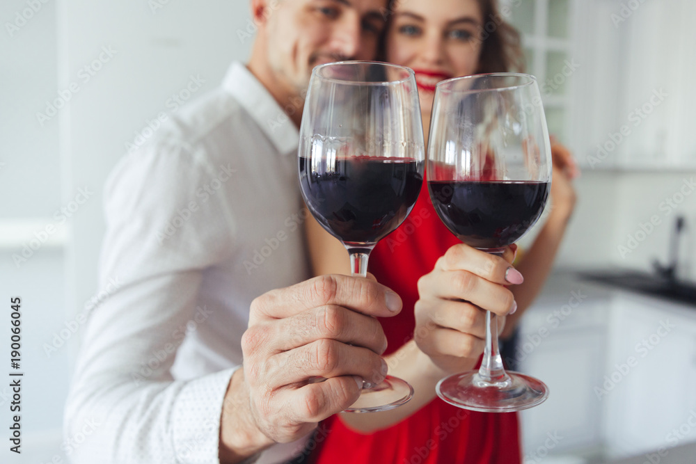 Close up of glasses with wine holding by pretty couple Close up of glasses with wine holding by pretty couple