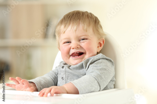 Joyful baby with his first teeth looking at you