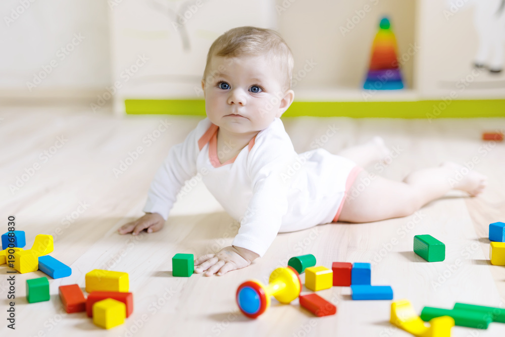 Cute baby girl playing with colorful rattle toys Cute baby girl playing with colorful rattle toys