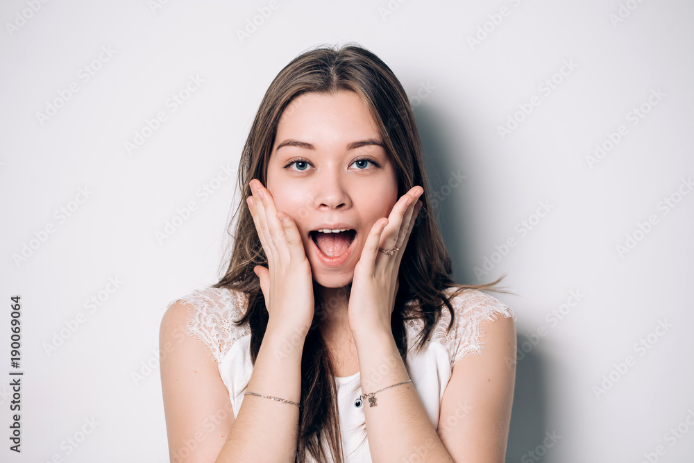 Woman surprise holds cheeks by hand Woman surprise holds cheeks by hand