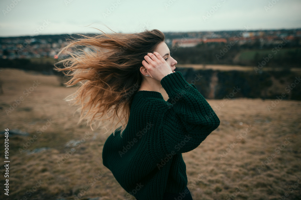 Cute girl with curly windy hair outdoor