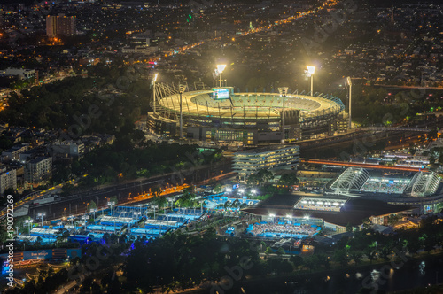 Melbourne Cricket Ground and Yarra Park tennis stadium illuminated at sunset. photo