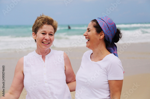 Outdoor portrait of two women standing on the beach