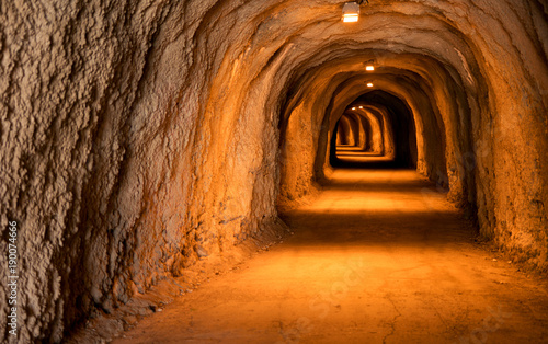 Fotografie, Obraz Empty underground mountain tunnel of sand color leaving in the distance illumina