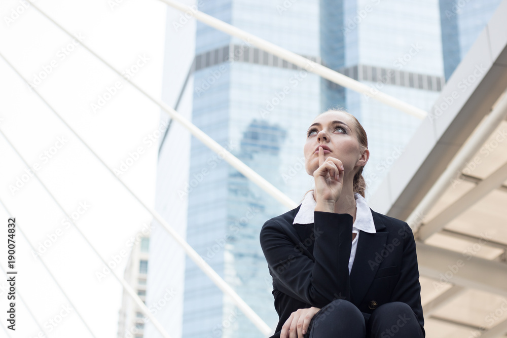 Businesswomen sitting on stair outside building and thinking and planning to future. Businesswomen sitting on stair outside building and thinking and planning to future.