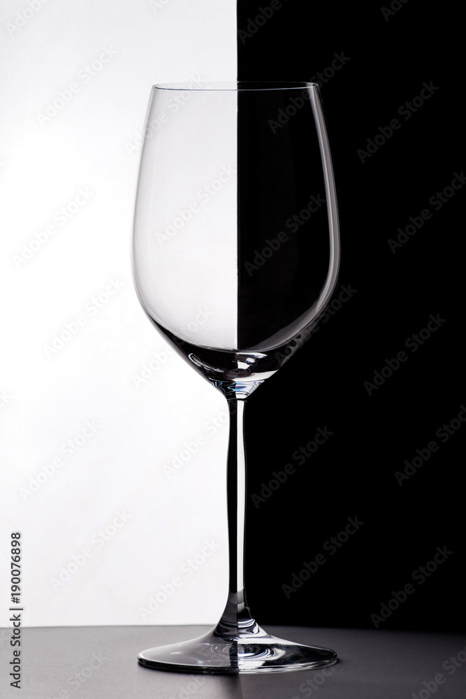 Wineglass on the border of black and white backgrounds. Wineglass on the border of black and white backgrounds.