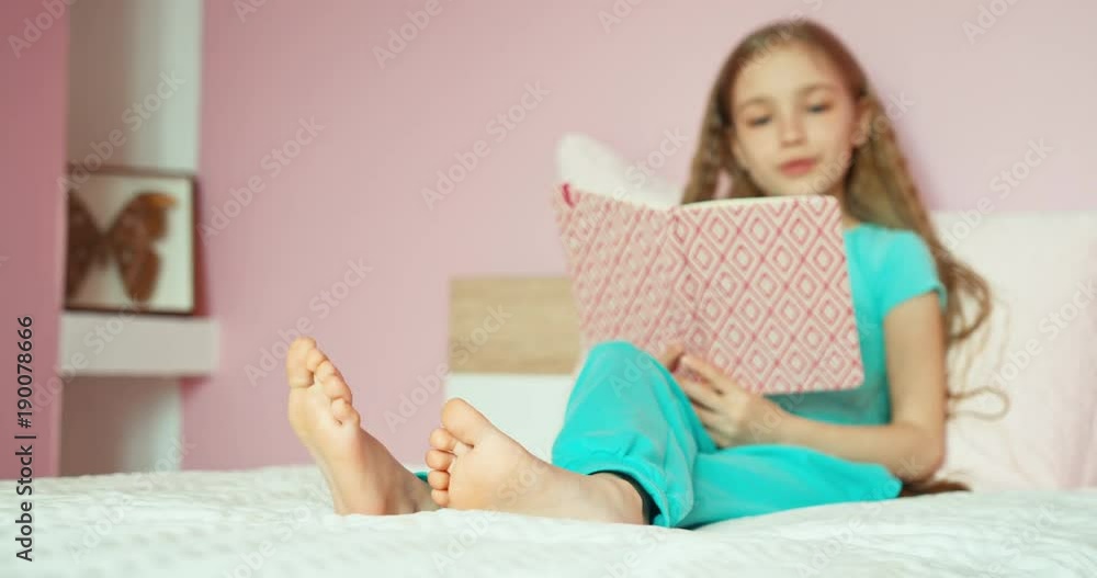 Schoolgirl reading on bed and laughing Schoolgirl reading on bed and laughing