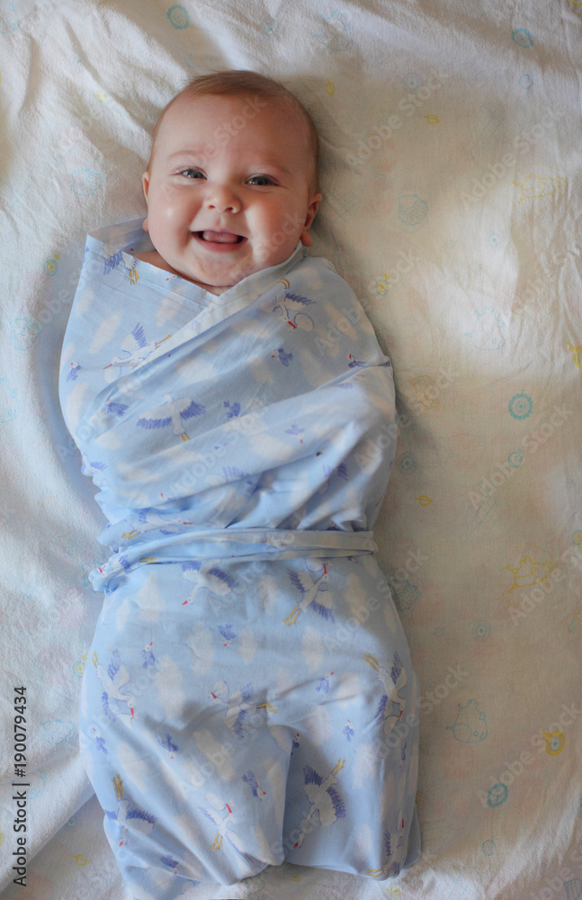 Baby wrapped in a diaper. Newborn in the crib. Care of young children