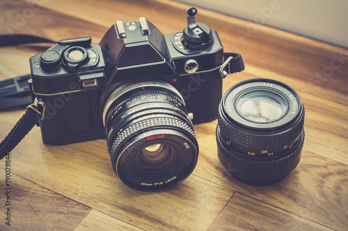 un ancien appareil photo avec un flash installé au milieu d'un fond en bois marron