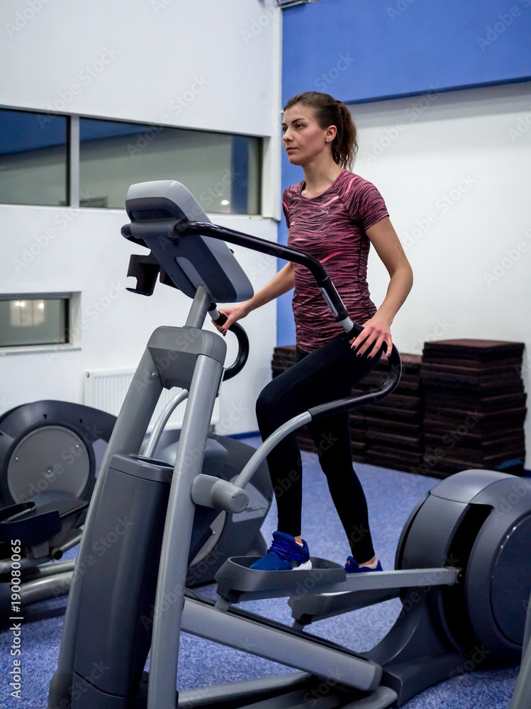 Young model girl makes exercises at the gym in front of mirror Young model girl makes exercises at the gym in front of mirror