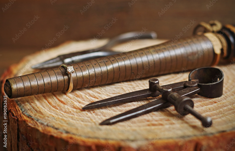 Antique jewelry tools and jewel on wood