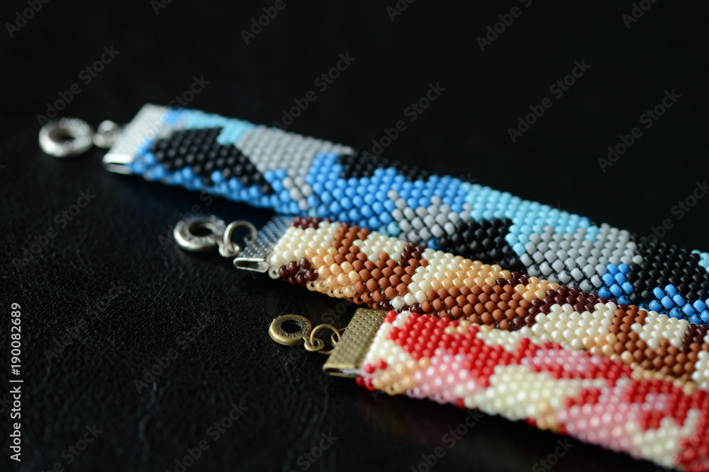 Three camouflage bracelets on a dark background close up Three camouflage bracelets on a dark background close up