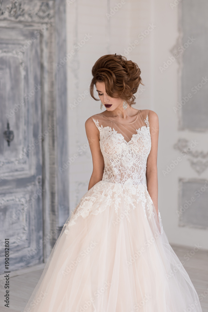 Morning of the bride. A beautiful bride stands in a wedding dress. Morning of the bride. A beautiful bride stands in a wedding dress.