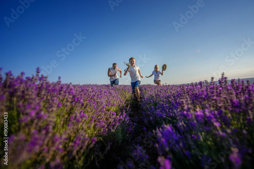 Happy family in a field of lavender on sunset.