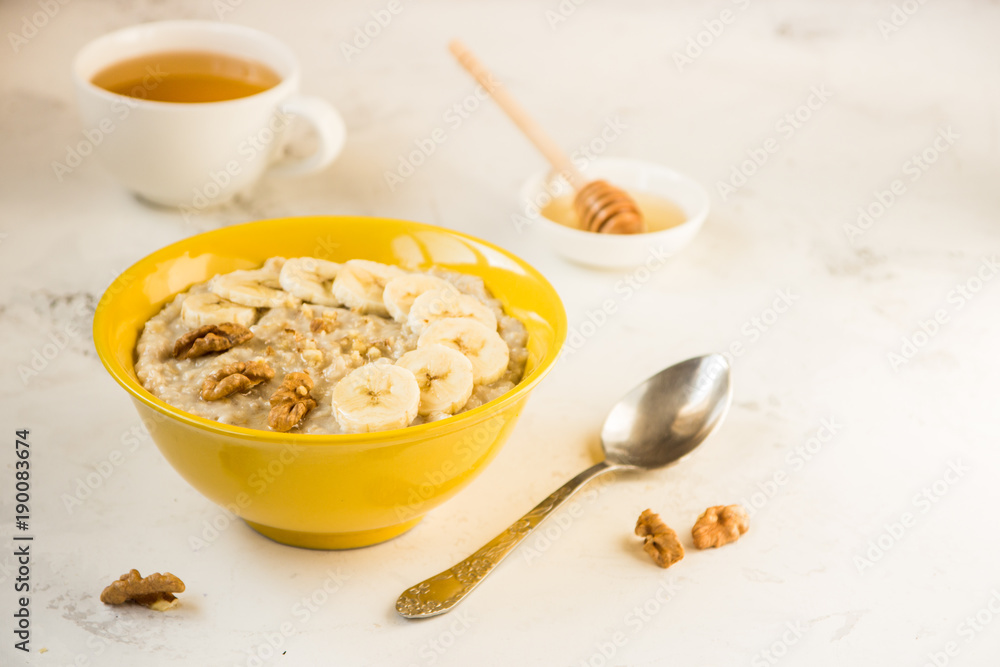 Oatmeal with banana and honey. Porridge in a yellow bowl Oatmeal with banana and honey. Porridge in a yellow bowl
