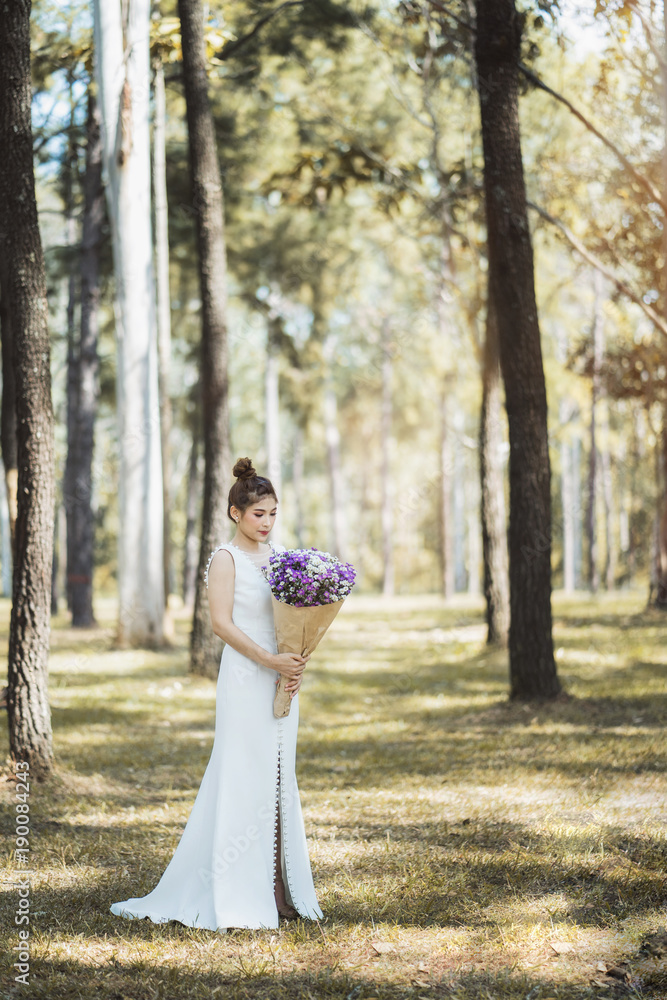 Portrait of Asian bride in a white lace wedding dress holding a bouquet. Portrait of Asian bride in a white lace wedding dress holding a bouquet.