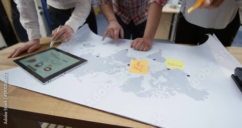 Wallpaper Mural 4K Business partners with startup company looking at world map & tablet, strategizing their business development. Slow motion. Torontodigital.ca