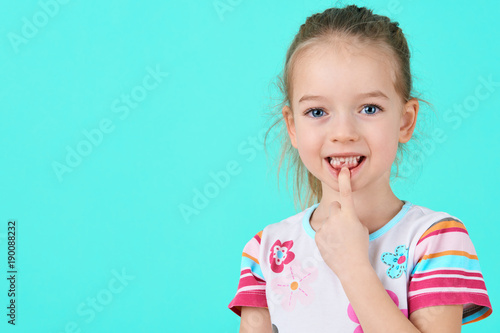 Adorable little girl smiling and showing off her first lost milk tooth. Cute preschooler portrait after dropping her front baby tooth.