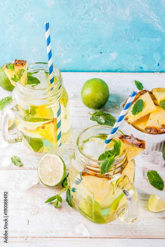 Tropical drink,  Pineapple mojito or lemonade with fresh lime and mint  light blue background, copy space