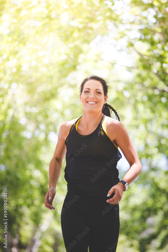 Beautiful brunette female fitness model running / stretching / exercising outside in a leafy and green suburb Beautiful brunette female fitness model running / stretching / exercising outside in a leafy and green suburb