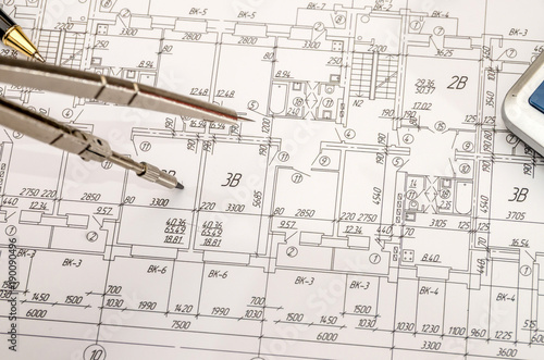 architectural construction documents with pen and calculator