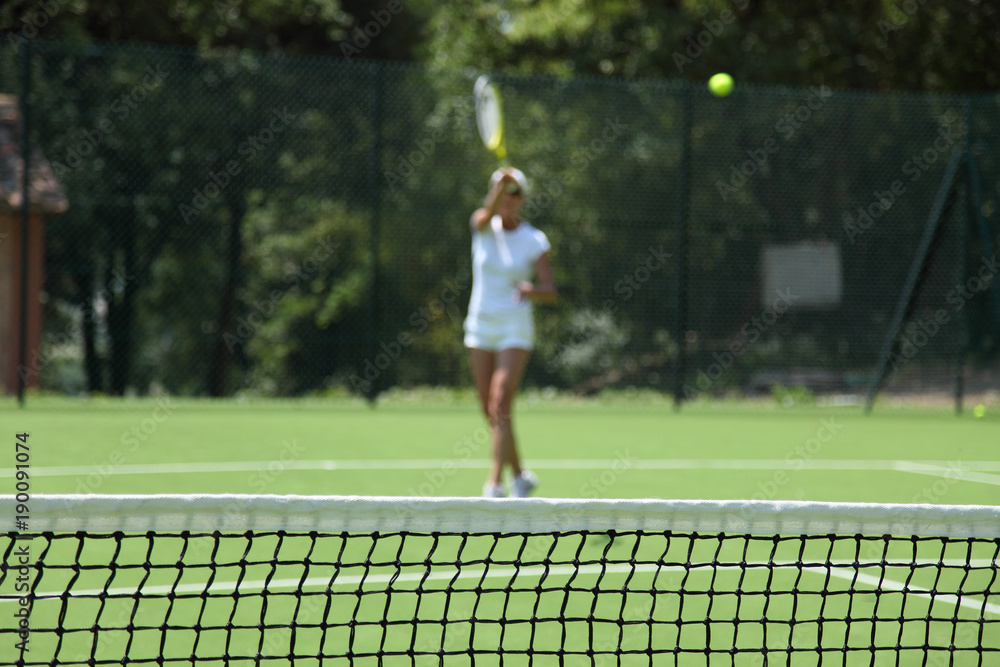 blurred woman playing tennis in a green field blurred woman playing tennis in a green field