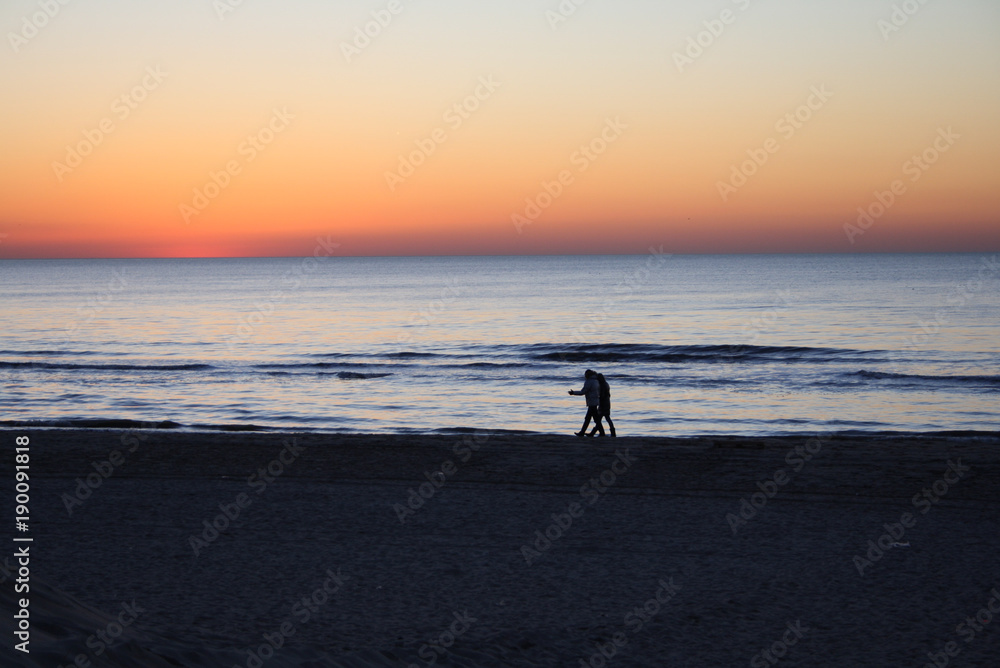 Strandspaziergang bei dem Sonnenuntergang