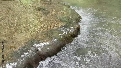  Beautiful clear water stream flowing through natural mountain rocks.