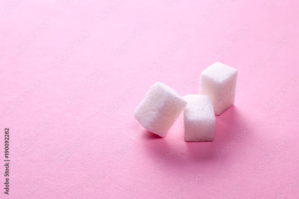 Cubes of white sugar on a pink background. Copy space for text Cubes of white sugar on a pink background. Copy space for text