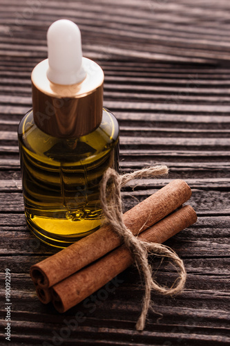 Cinnamon essential oil on a wooden background