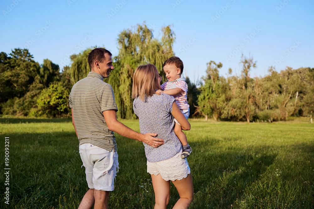 Happy family in nature. Parents with a child play in park. Happy family in nature. Parents with a child play in park.