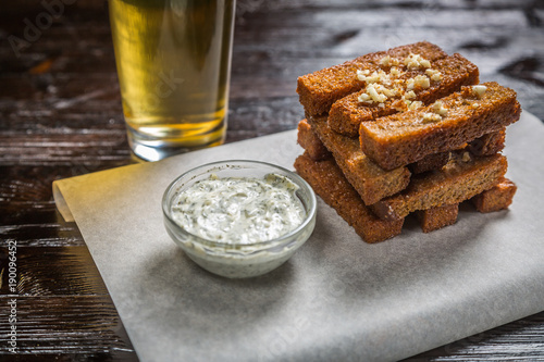 Fotografi Beer snack of bread toast with garlic, with sauce on the Board for filing is cov