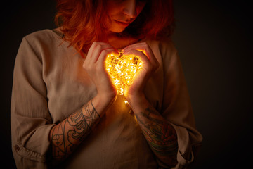 Woman holding lights in the shape of a heart