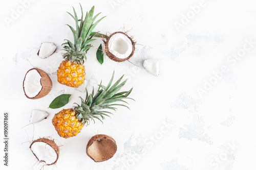Fruit background. Pineapples and coconuts on white background. Summer fruits. Flat lay  top view  copy space