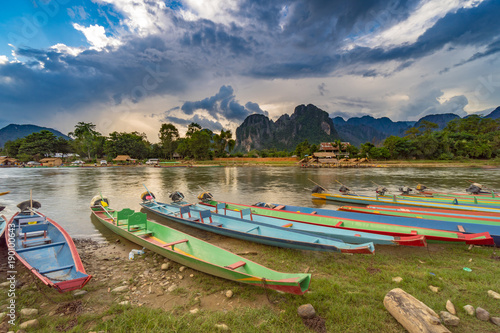 long tail boats on sunset at Song river, Vang Vieng, Laos.