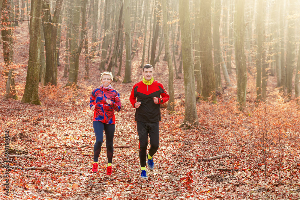 Couple jogging and running outdoors in nature. Sport series.