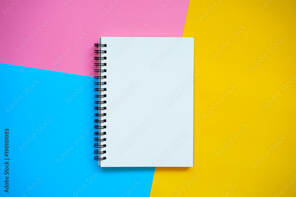 Top view of Blank notebook on colorful background pink blue yellow with copy space. - obrazy, fototapety, plakaty 