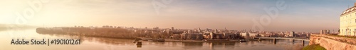 Panoramic view of Novi Sad, Serbia cityscape with two bridges, Danube river and part of the Petrovaradin fortress in the beautiful evening sundown, image with film grain